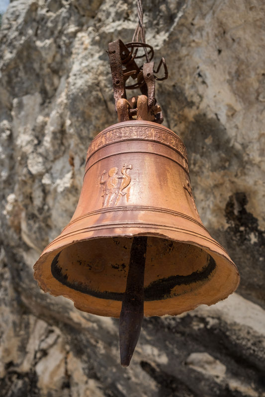 Zvon zavěšený u kaple Panagia Spileotissa.
